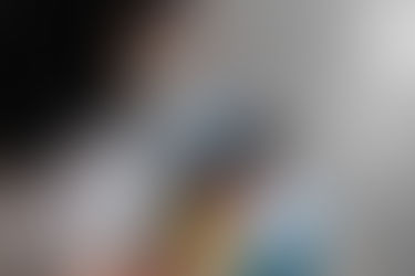 A college student studying with a textbook open and using AI on a smartphone, representing eco-friendly AI usage and digital learning.