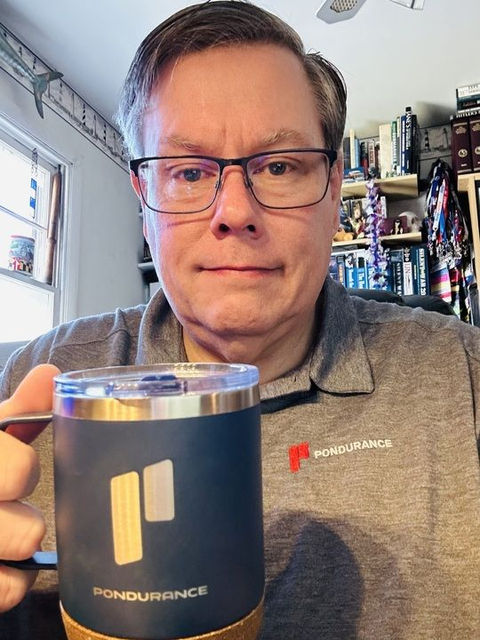 man holding pondurance coffee cup looking at camera