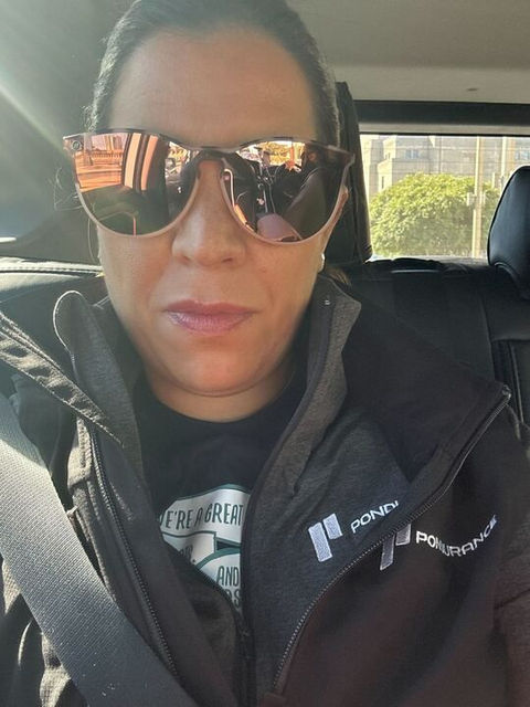 woman in sunglasses taking selfie in car