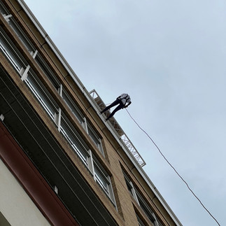 looking up at abseiler coming down the side of Chelsea & Westminster Hospital