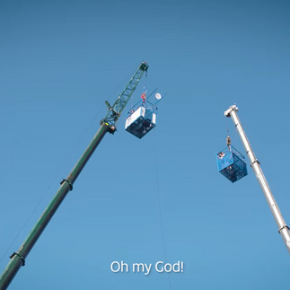 Two cranes with bungee cages, with a contestant saying 'oh my God!'