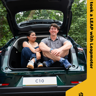 Two people sitting in the boot of a car