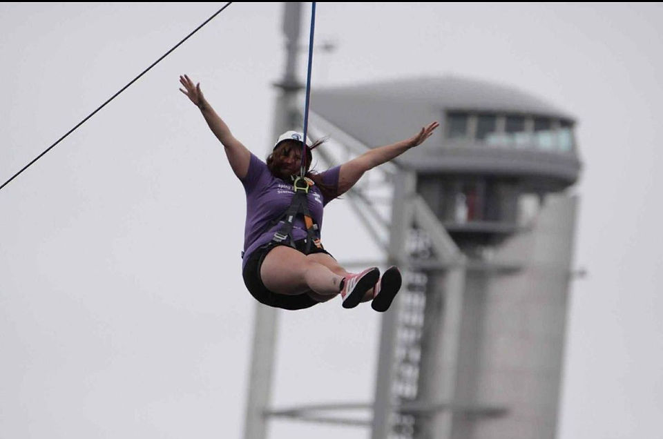 Woman on zip wire with hands in the air