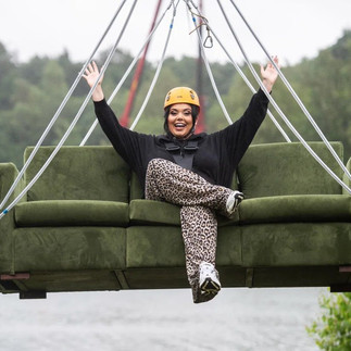 Scarlett Moffat with her hands in the air on the sofa zip wire