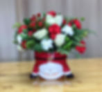 A Santa Claus floral arrangement featuring red roses, white roses and assorted white flowers.