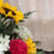 A 360 degree view of bold lilies, vibrant hydrangeas, classic carnations, and fragrant eucalyptus bouquet on a rustic table.