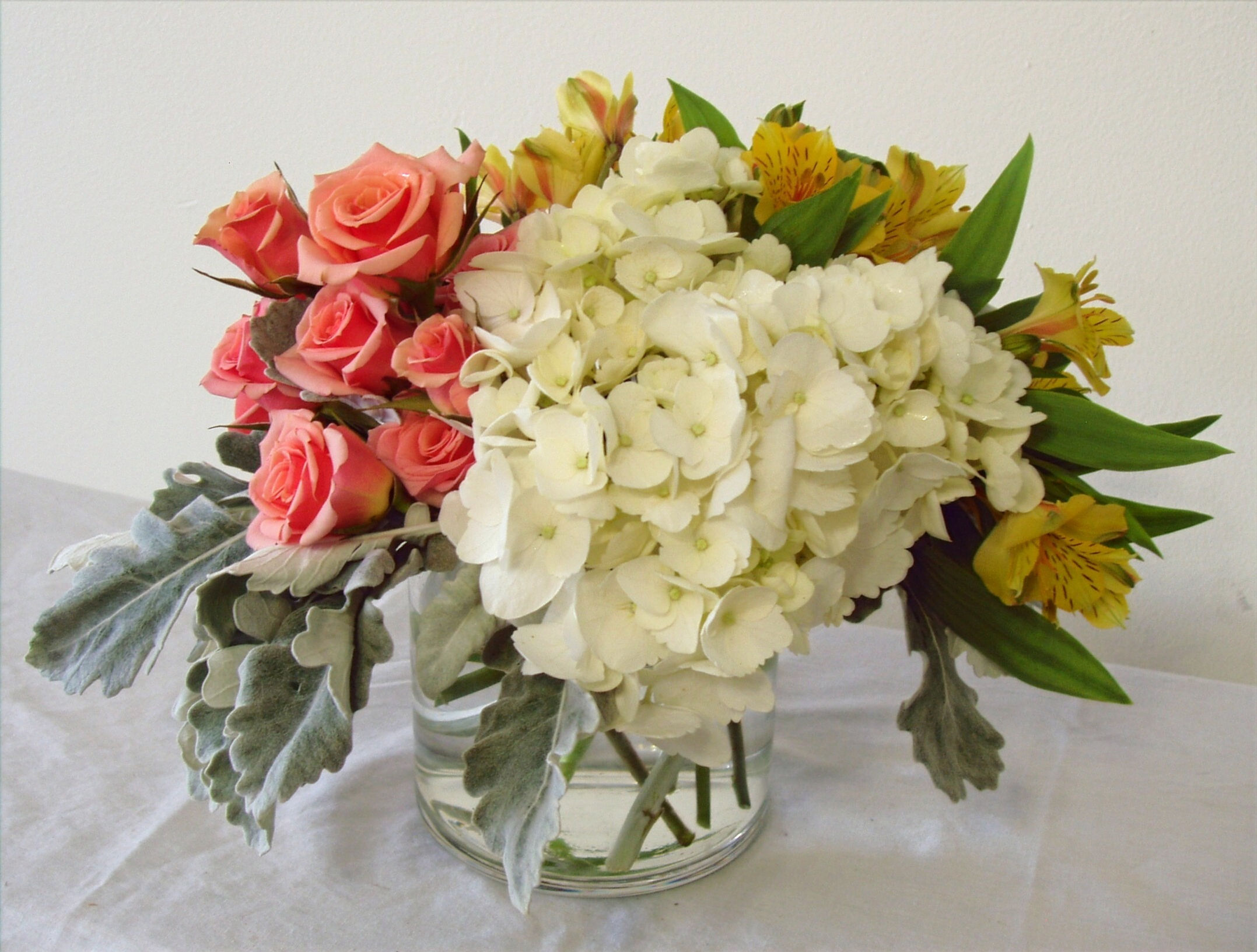 Bouquet of Serenity Now with pink roses, white hydrangea, and yellow alstroemeria, exuding tranquility