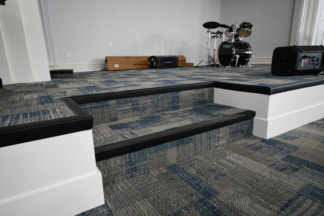 Patterned blue commercial carpet installed by Quality Craft Floors in a Covina church, including stage and steps, for a durable and cohesive finish.