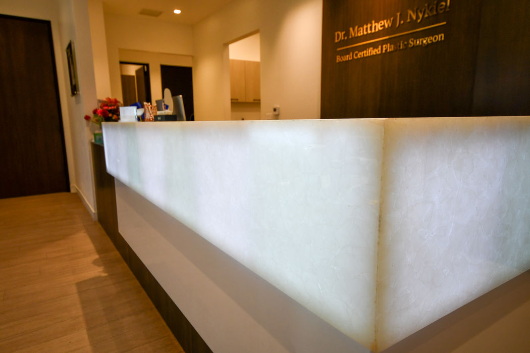 Reception desk with soft backlighting and wood finishes supplied by Quality Craft Floors in Claremont