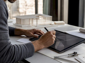 Architect holding pen over tablet in design studio