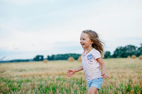 blonde child playing in meadow