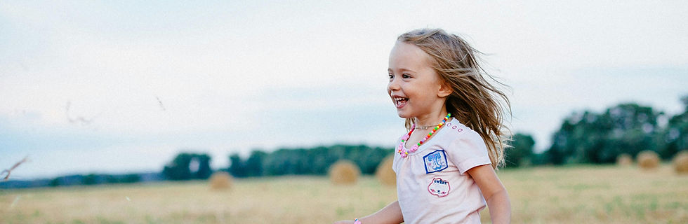 blonde child playing in meadow