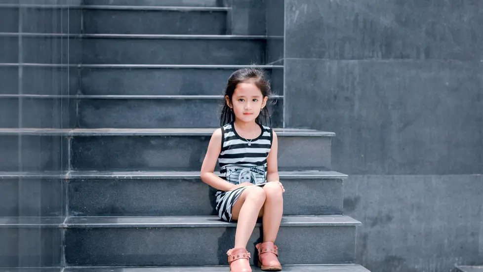child sitting on courthouse steps waiting for parents in child custody case