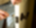 Person installing a door knob using a screwdriver. Close-up shows a white door and black handle, with light beige background.
