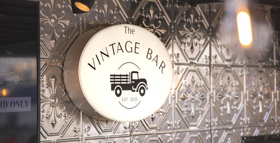 The Vintage Bar Logo with Pressed Metal backdrop