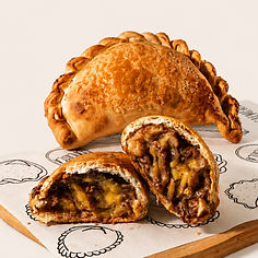 Empanada artesanal de banana com especiarias da La Chica, aberta ao meio com recheio cremoso e massa dourada crocante.