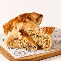 Empanada artesanal de frango com Catupiry® da La Chica, aberta ao meio com recheio cremoso e massa dourada crocante.