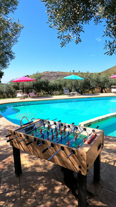 Area giochi all'aperto tra cui calcio balilla e ping pong nei pressi dell'area piscina e giardino 