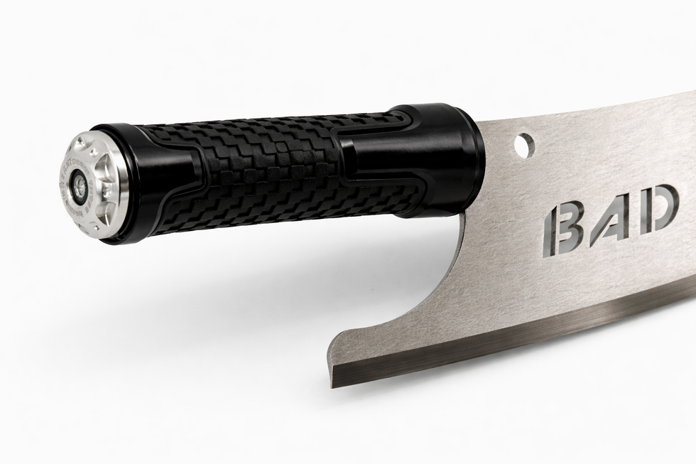 Close-up of a black textured knife handle and metal "BAD" blade.