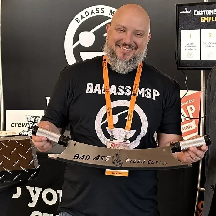Smiling man in BADASS MSP shirt holding a BADASS MSP trophy