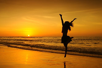 Happy Woman Jumping in Sea Sunset.jpg