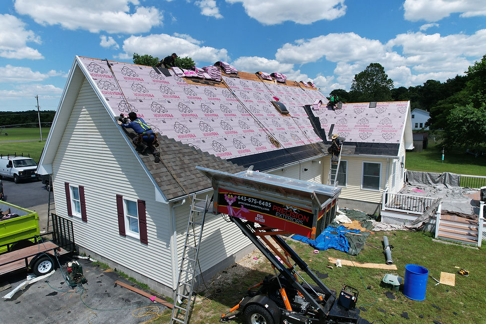 Workers installing new roof on house with blue sky and trees Roof Replacement Roofing Contractor