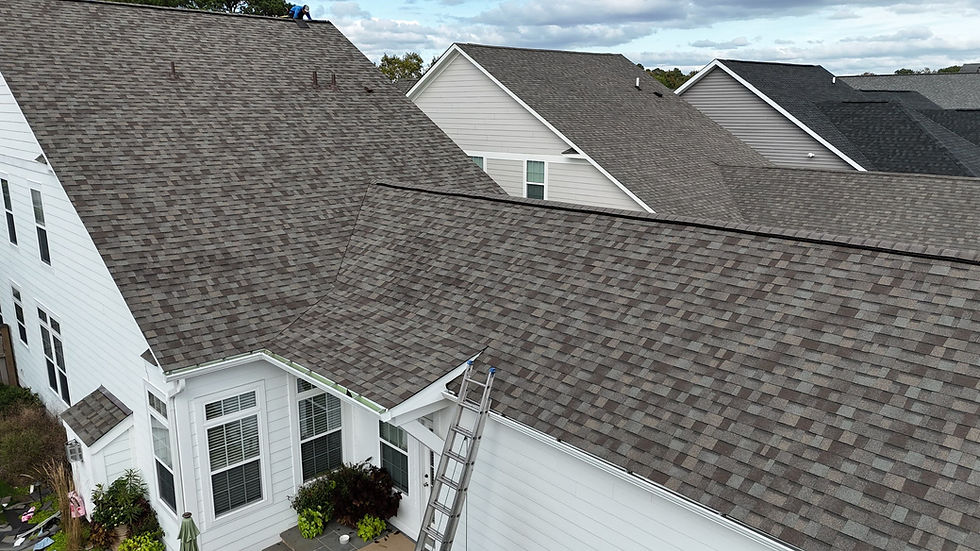 Residential homes with new asphalt shingle roofs and a roofing contractor.
