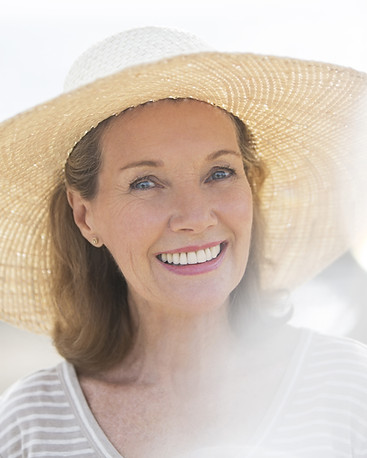 Older woman wearing straw hat on beach
