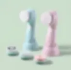 Two blue and pink electric facial cleansing brushes with interchangeable heads.