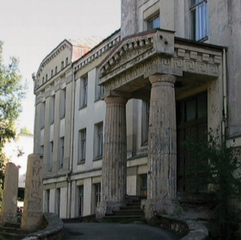 Grand old mansion with large fluted columns at its imposing entrance.