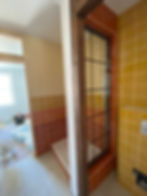 Newly tiled wall beside a timber door with glazed panels