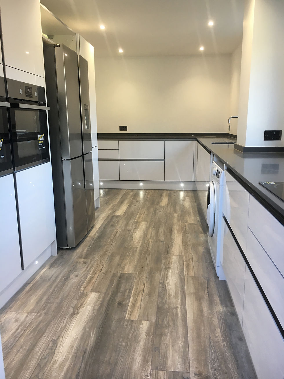 Modern bespoke kitchen renovations with wood-style flooring
