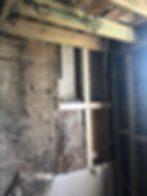 Exposed lath and plaster wall with timber framing in a bathroom renovation