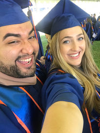 Leyder "Aiden" Murillo in cap and gown, smiling alongside a friend after graduating with an MBA in Finance from Pepperdine.