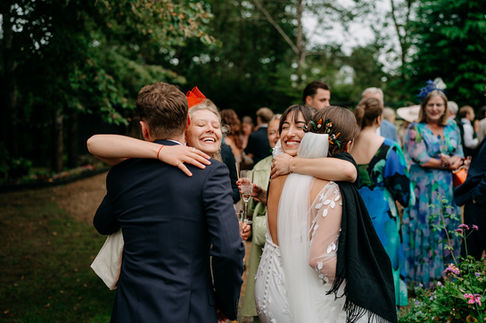 candid photo of the bride and groom getting hugs from wedding guests at rumbolds farm