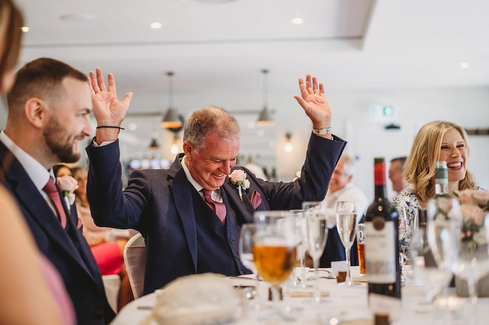 father of the groom with his hands up during speeches at Cottesmore wedding, documentary wedding photographer Sussex
