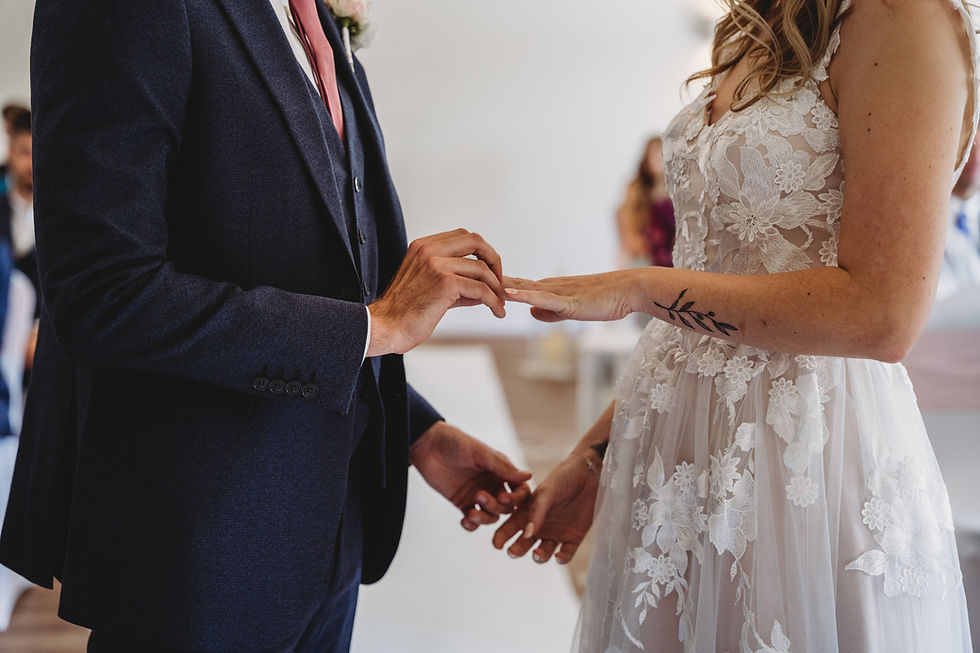 bride and groom exchanging rings at Cottesmore indoor ceremony venue, Cottesmore golf club wedding
