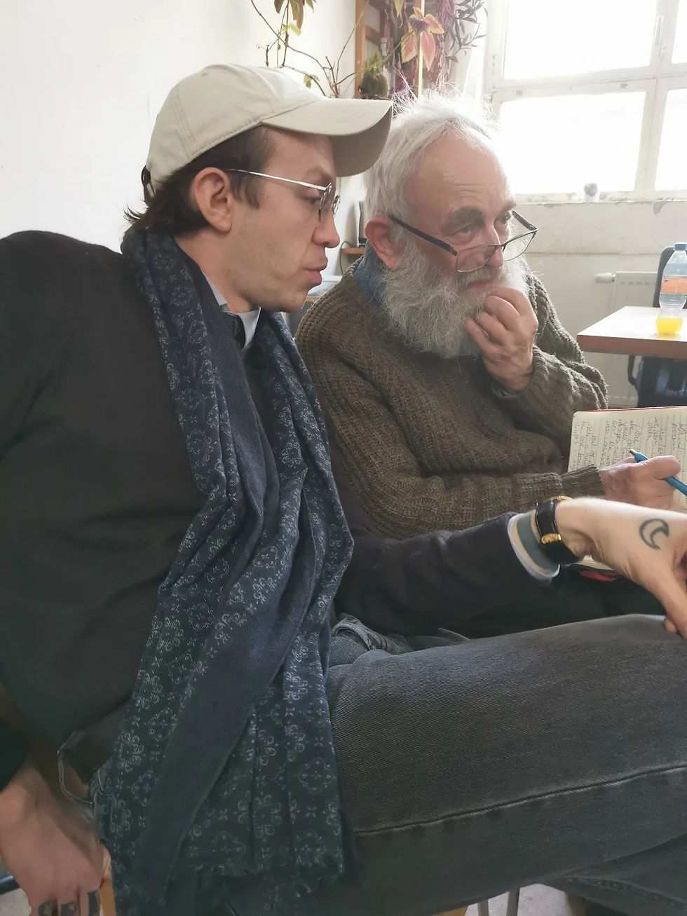 Rudi, a member of the Kampagne für eine Sozialistische Partei (KSP), translates discussions for John Hoggett during a conference session.