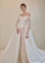 Off-the-shoulder corset bridal gown with lace sleeves and satin overskirt.