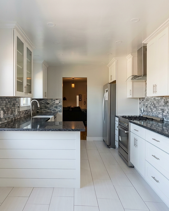 Modern kitchen by West Coastal Constru with white cabinets