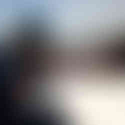 E1 Team Miami members sitting dockside under an umbrella, wearing team caps and sunglasses ahead of the race.