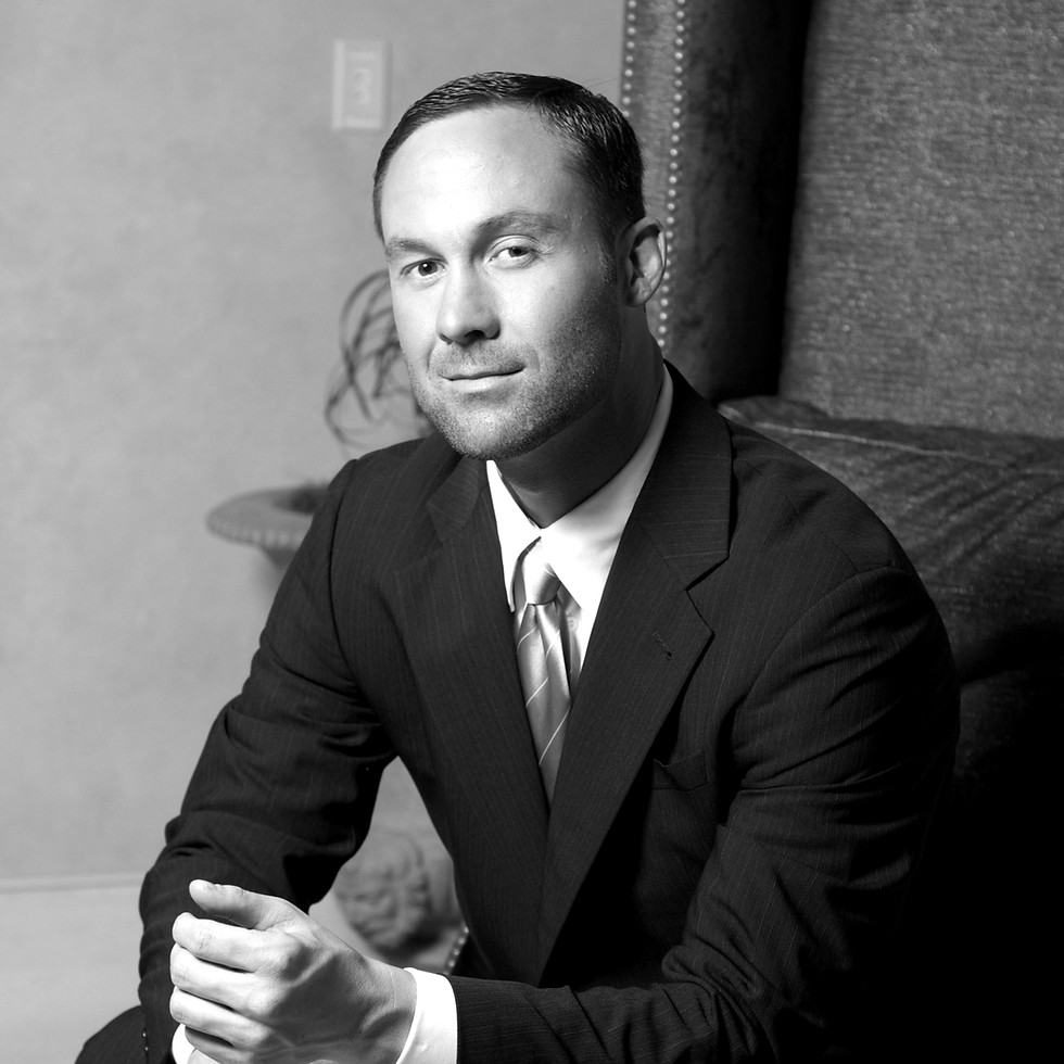 man in black suit jacket and black pants sitting on green sofa_edited.jpg