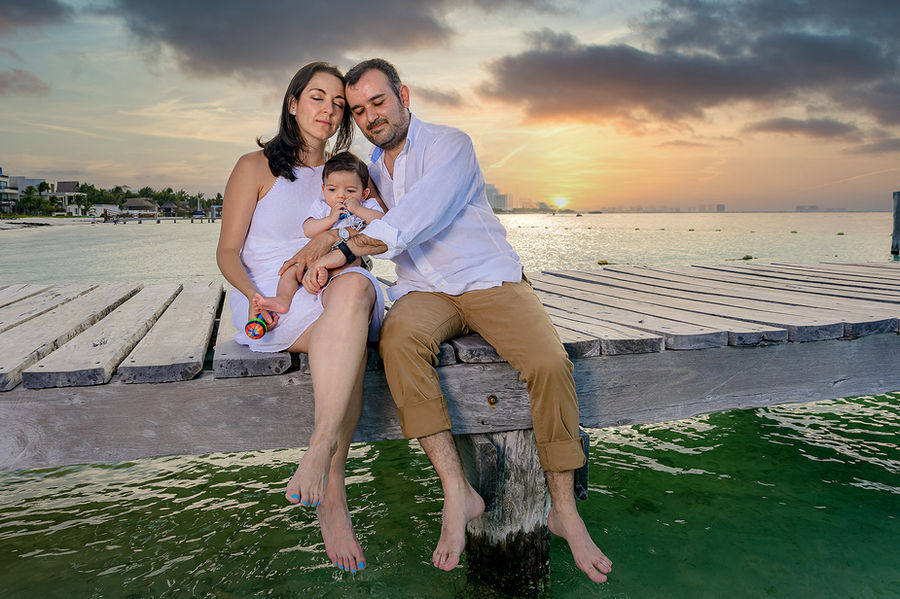 Familia feliz en muelle al atardecer