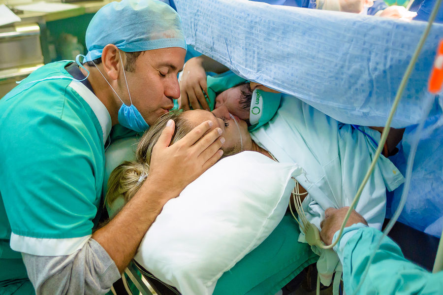 Padre besa a madre durante parto cesárea, Documental por Carlos Mendoza Photography