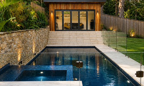 Luxury concrete pool and spa seamlessly connecting the home, pool house and landscaped gardens.