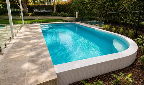 Elegant curved concrete pool creating a striking feature within a beautifully landscaped garden.