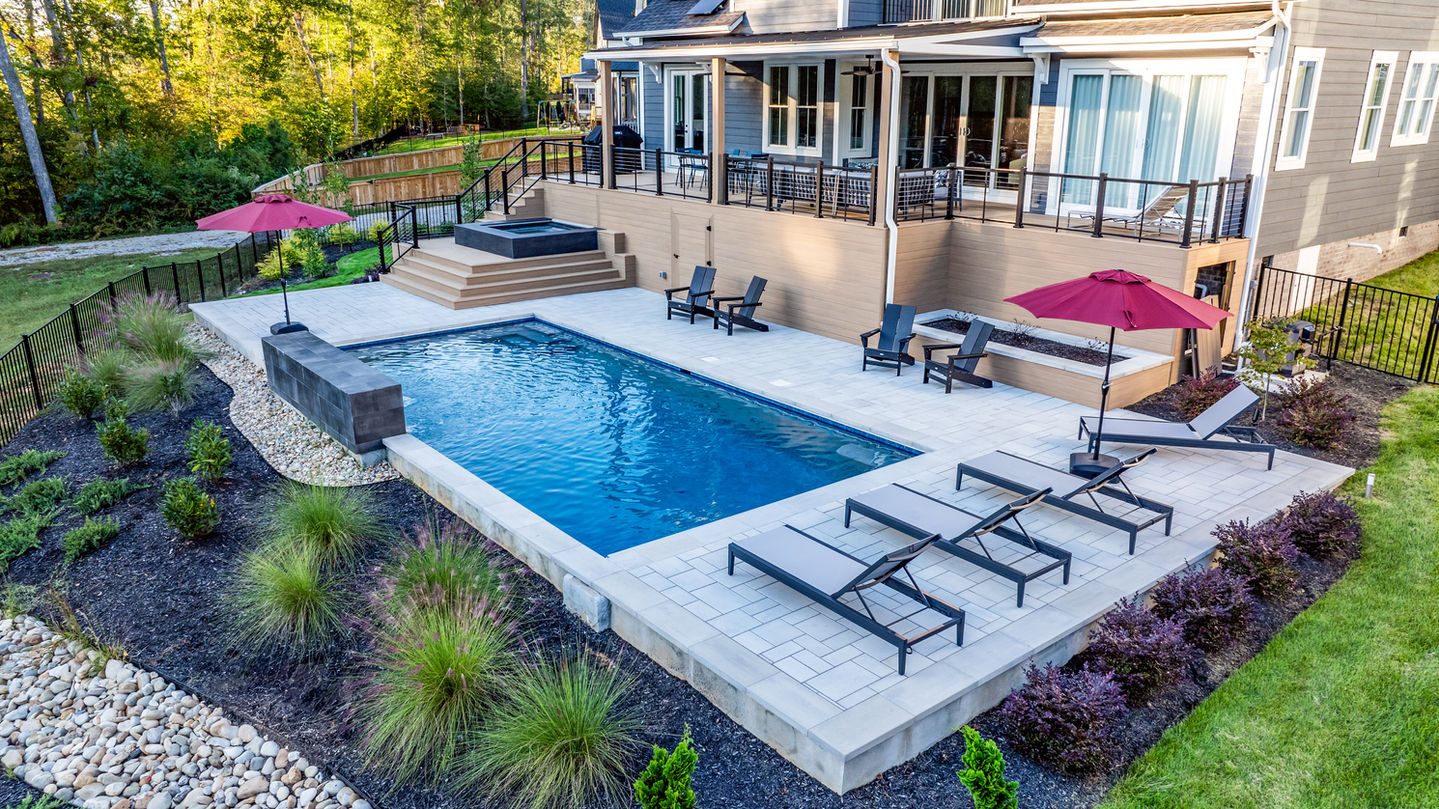 a large swimming pool surrounded by chairs and umbrellas