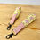 Thumbnail: Two pig wristlets on wood table