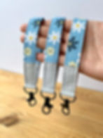Three blue summer flower wristlets being held in the hand, showing flower details