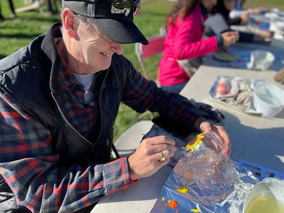 Man painting a glass at an outdoor corporate event